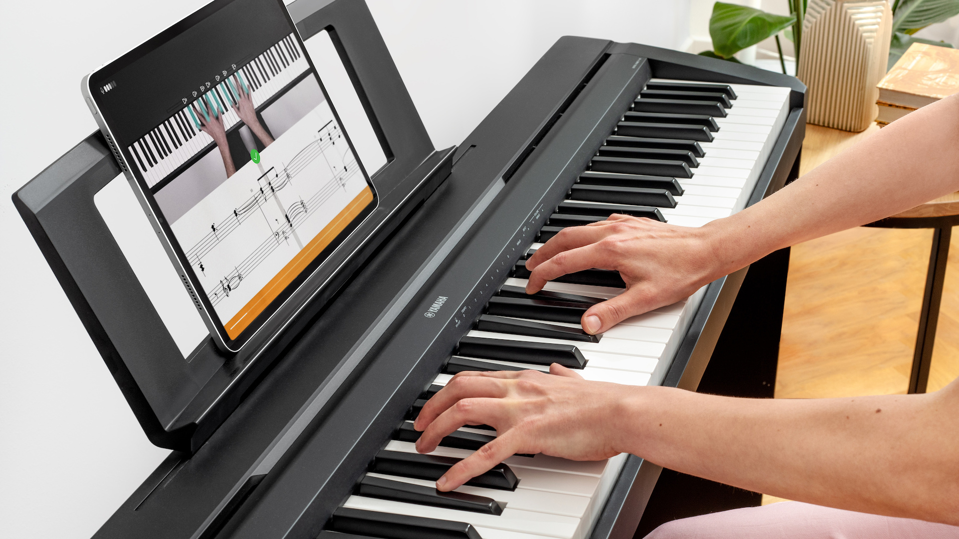 Nahaufnahe einer Piano spielenden Person mit einem Ipad auf dem die flowkey App abgebildet ist