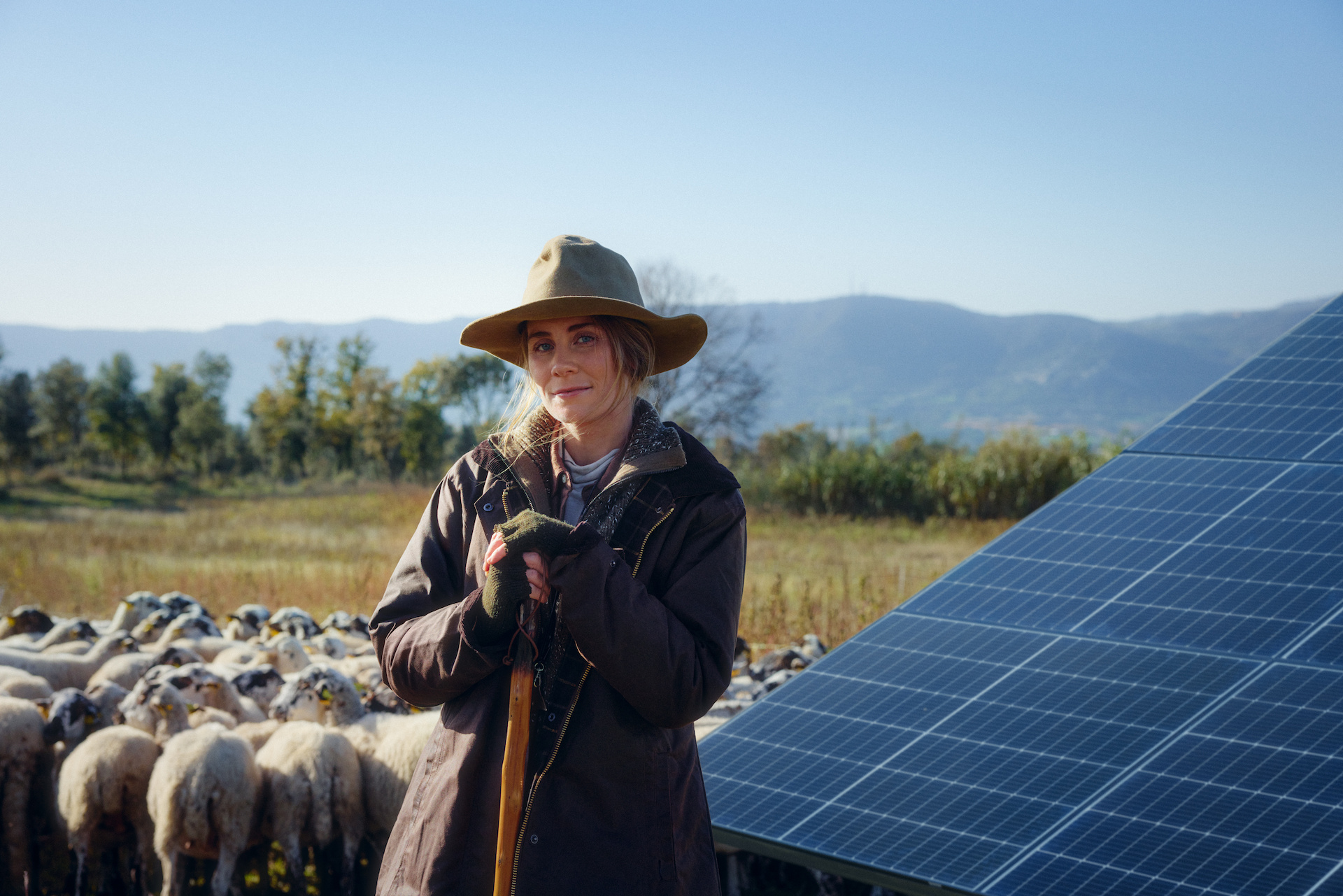 Frau auf Weide mit Solarpanels